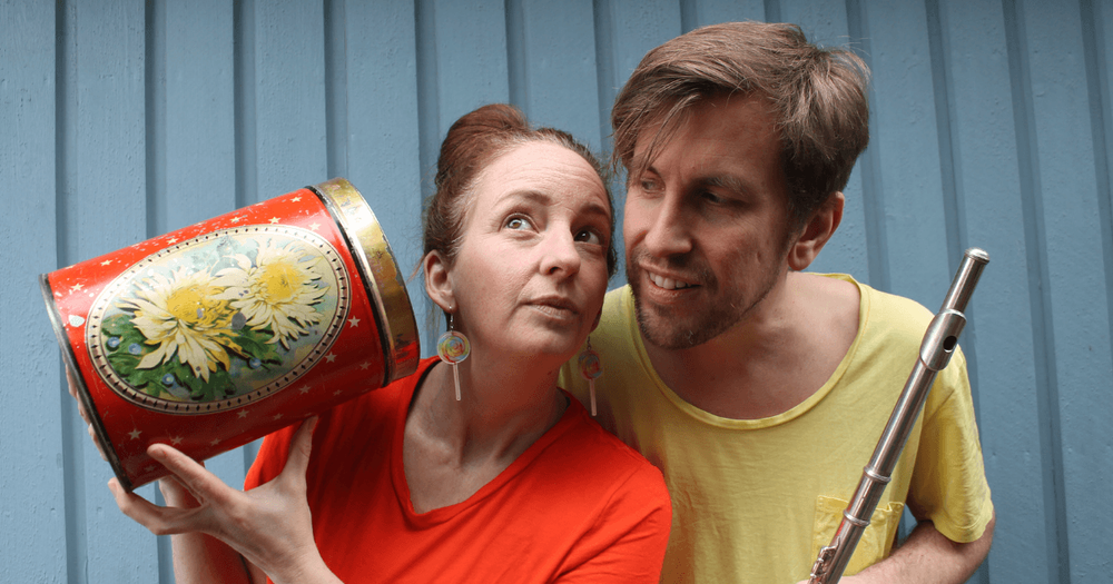 De två medverkande musikerna lyssnar på ljudet från en stor burk