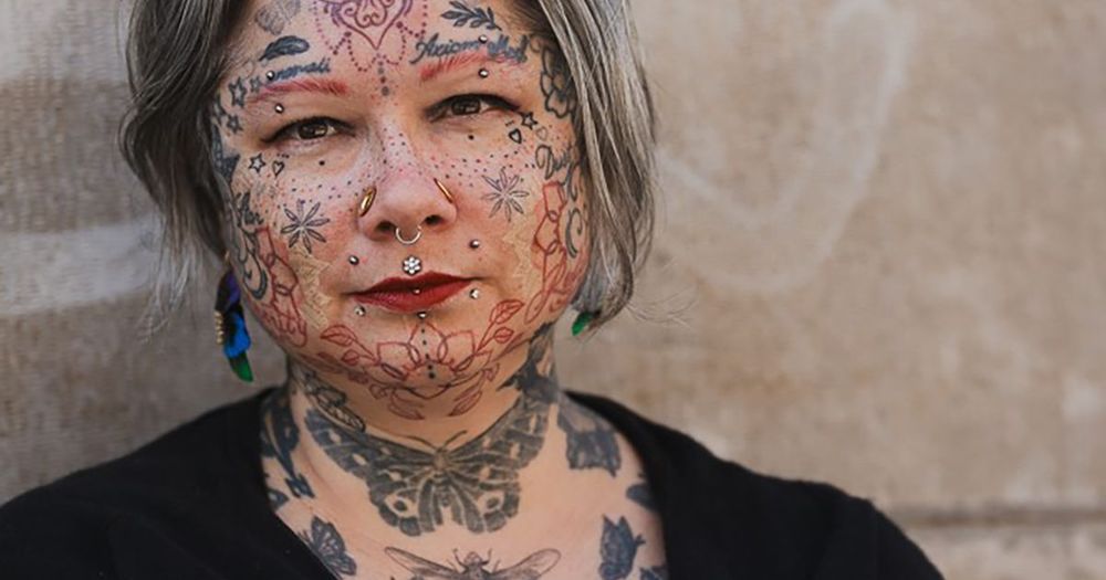 Kvinna med tatueringar i ansiktet och på halsen.