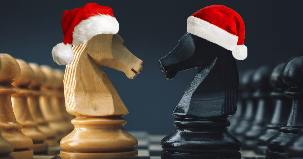 Två schackpjäser på ett bräde. Schackpjäserna har varsin tomteluva på toppen.