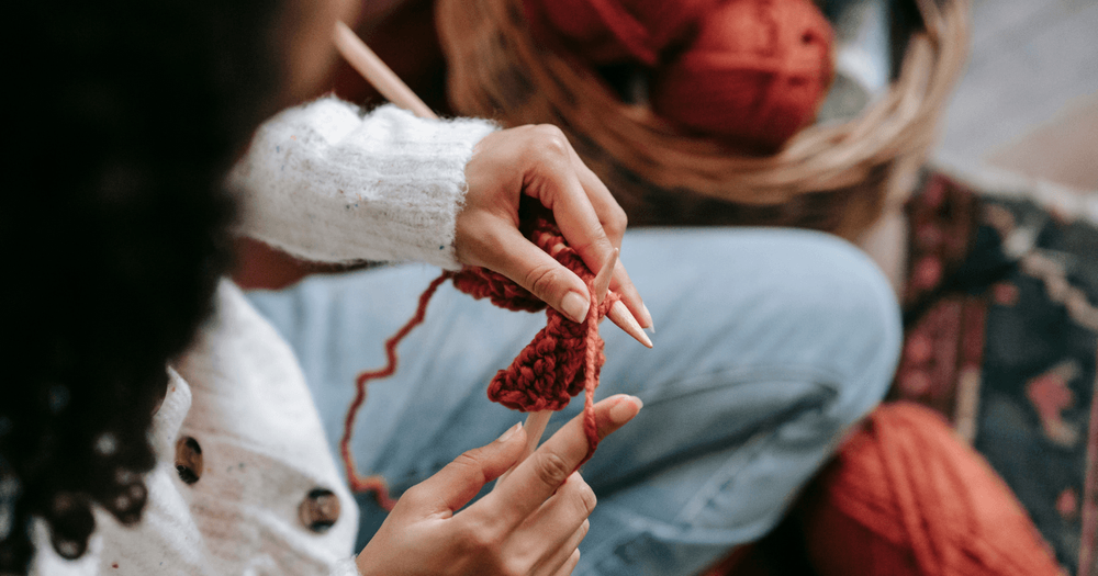 Person med stickning i knät. 