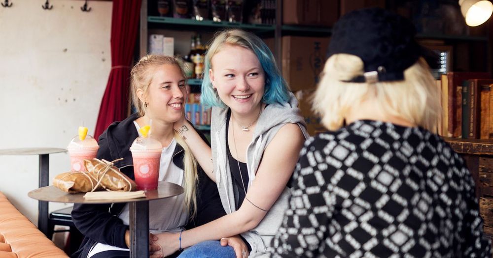 Flickor skrattar och fikar.