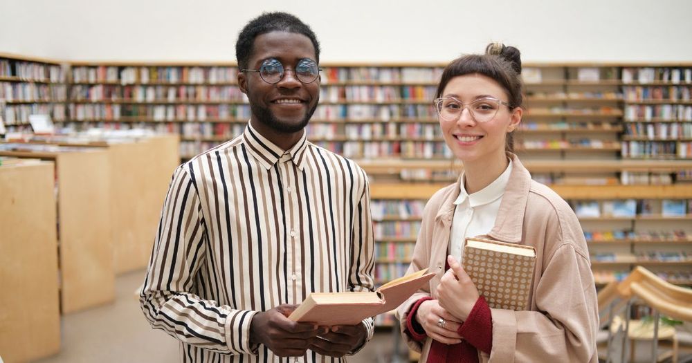 Två personer som befinner sig i ett bibliotek