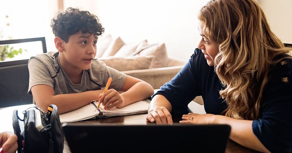 Ett barn och en vuxen läser läxor