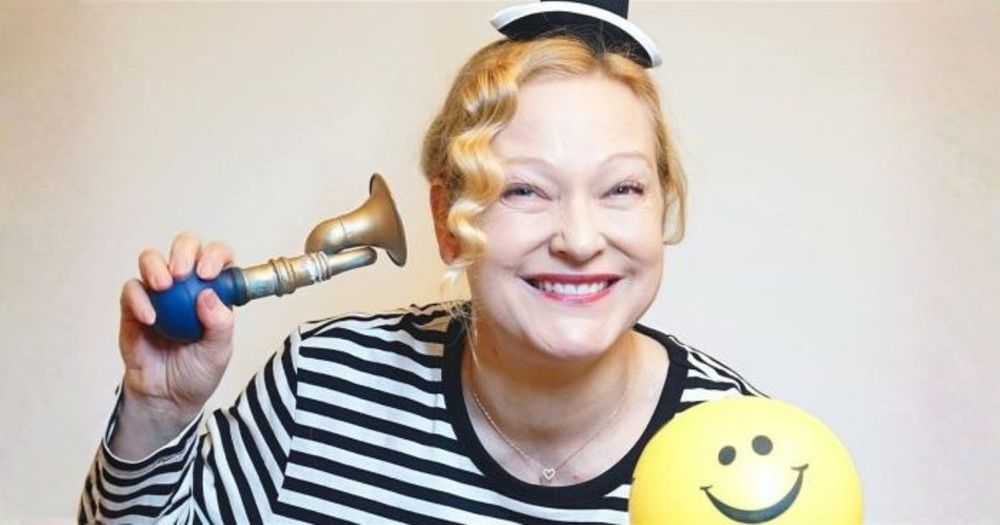 Kvinna med randig tröja, en ballong och en tuta.