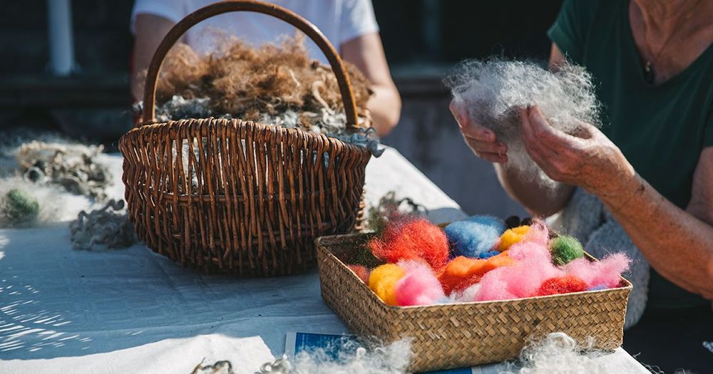 Handarbete, garn och ull i korgar på ett bord.